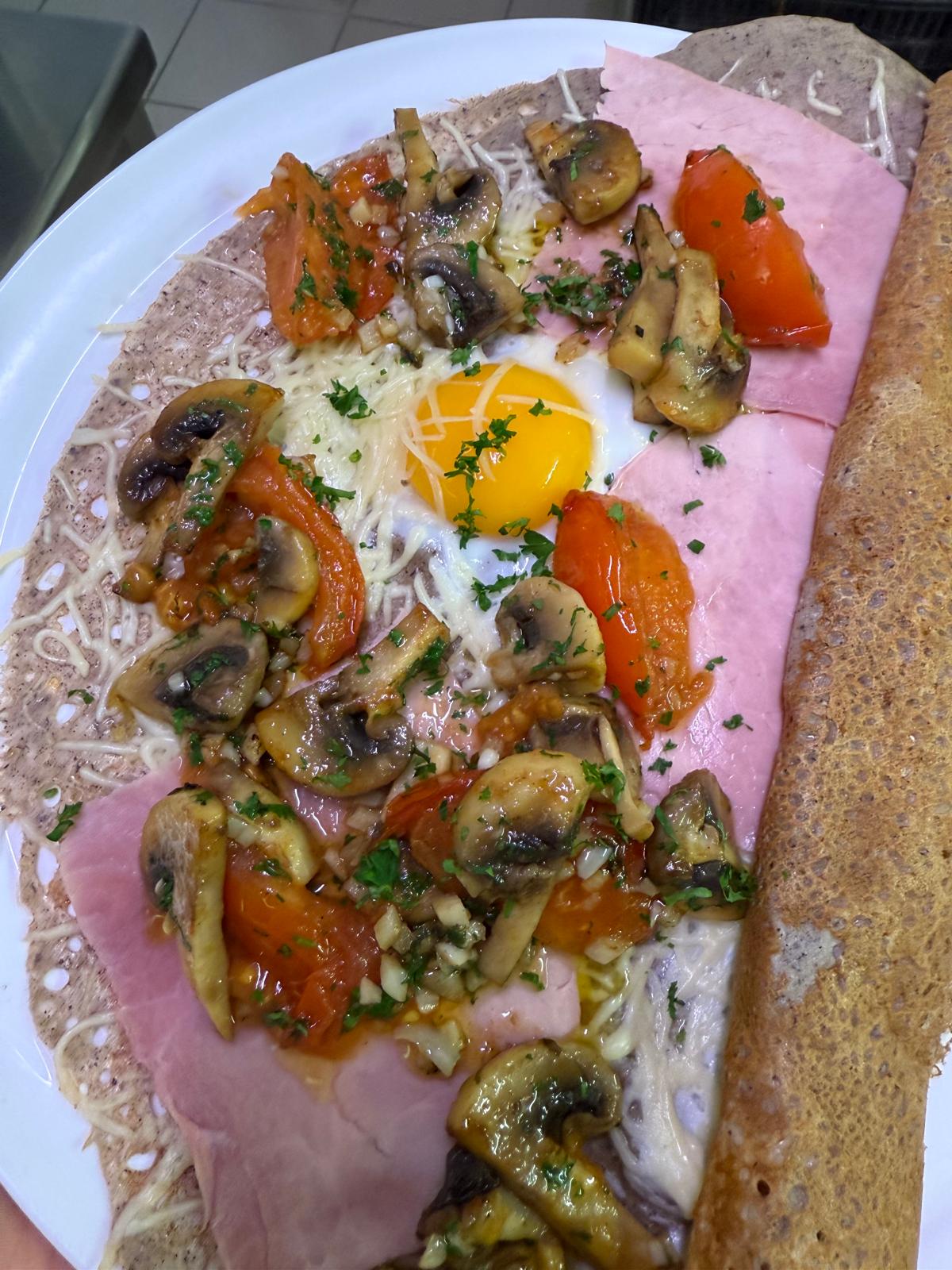 Galette complète au sarrasin avec jambon, œuf, fromage et champignons servie à La Bisquine à Pénestin