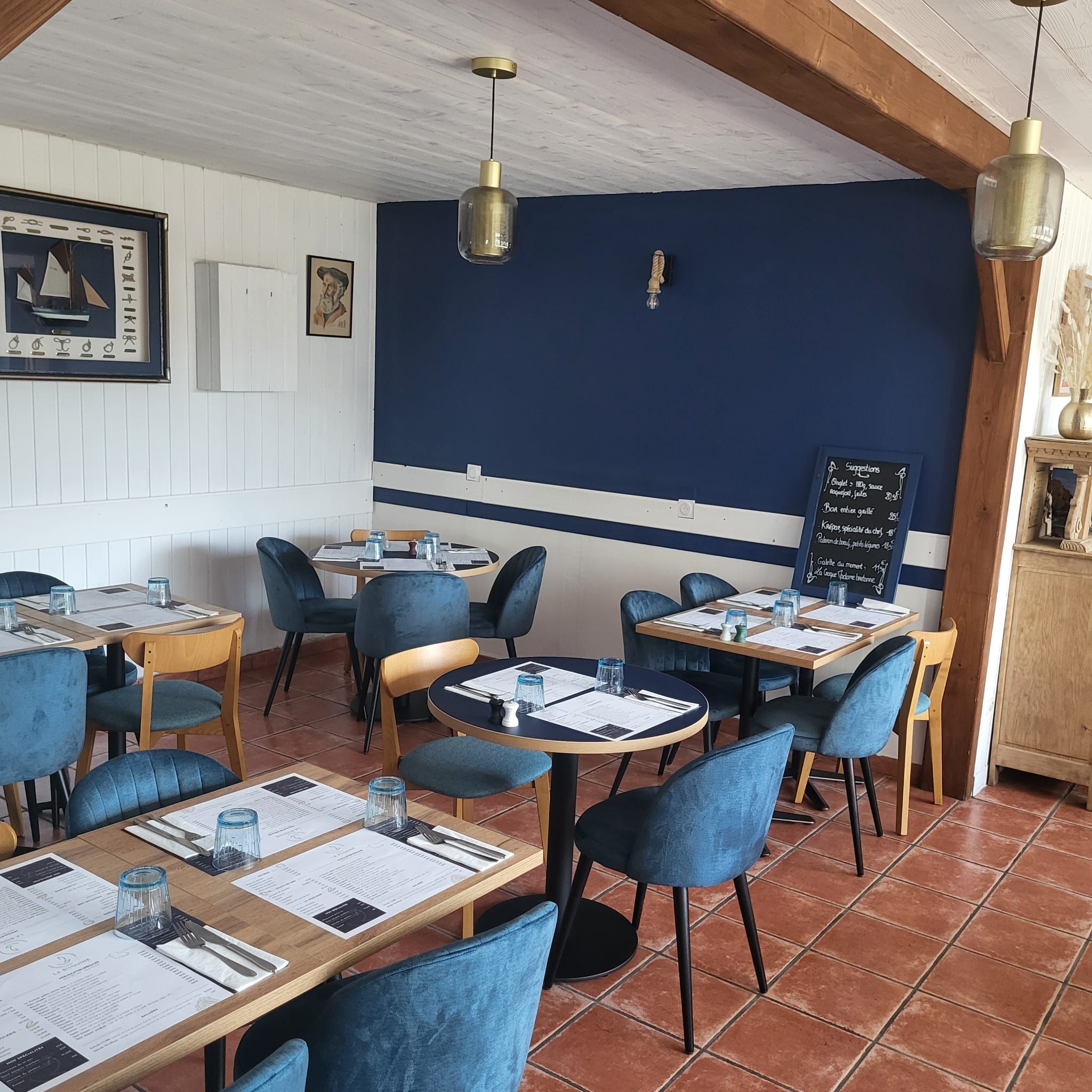 Salle de restaurant au style marin avec des tons bleu marine et bois, crêperie La Bisquine à Pénestin
